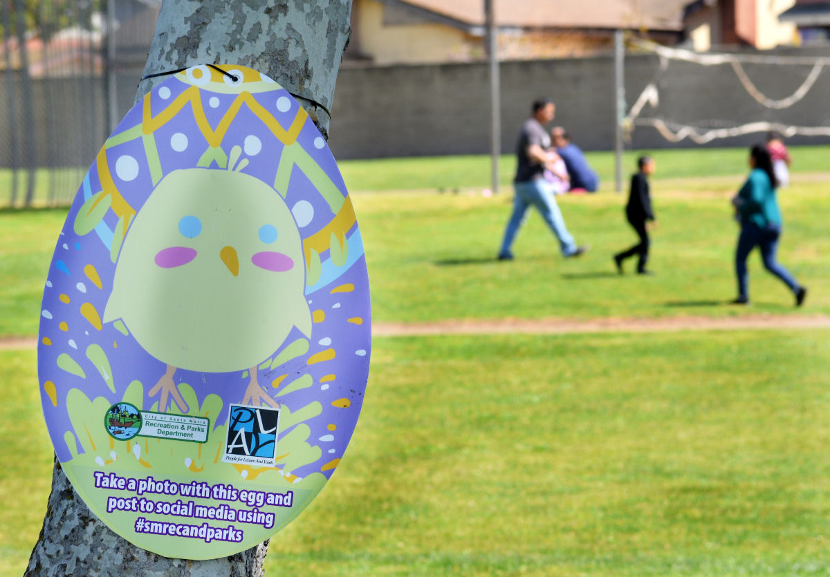 Community members walk around Minami Park Friday afternoon during the city wide virtual egg hunt.